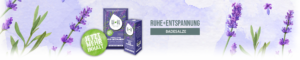 Ein langes Banner und in der Mitte des Bildes sind die Produkte "Badekonzentrat Lavendel Ruhe + Entspannung" und "Badesalz Lavendel Ruhe + Entspannung" abgebildet. Daneben steht in großen grauen Buchstaben "Ruhe + Entspannung" und in einem kleineren grauen Kästchen ist der weiße Schriftzug "Badesalze" abgebildet. Neben den beiden Produkten ist ein grüner Kreis mit dem Text "Jetzt mehr Inhalt" abgebildet. Der Hintergrund ist violett gestaltet und um das Produkt herum sind Lavendel Blüten und Blätter abgebildet.