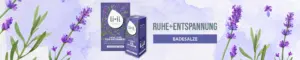 Das Badekonzentrat und das Badesalz Ruhe + Entspannung mit Lavendel ist abgebildet. In grauer Schrift steht daneben "Ruhe + Entspannung" und darunter in einem violetten Kästchen in weißer Schrift "Badesalze". Der Hintergrund ist leicht violett und transparent und verschiedene Lavendel Zweige sind ebenfalls im Hintergrund zu erkennen, teilweise auch wieder leicht transparent.